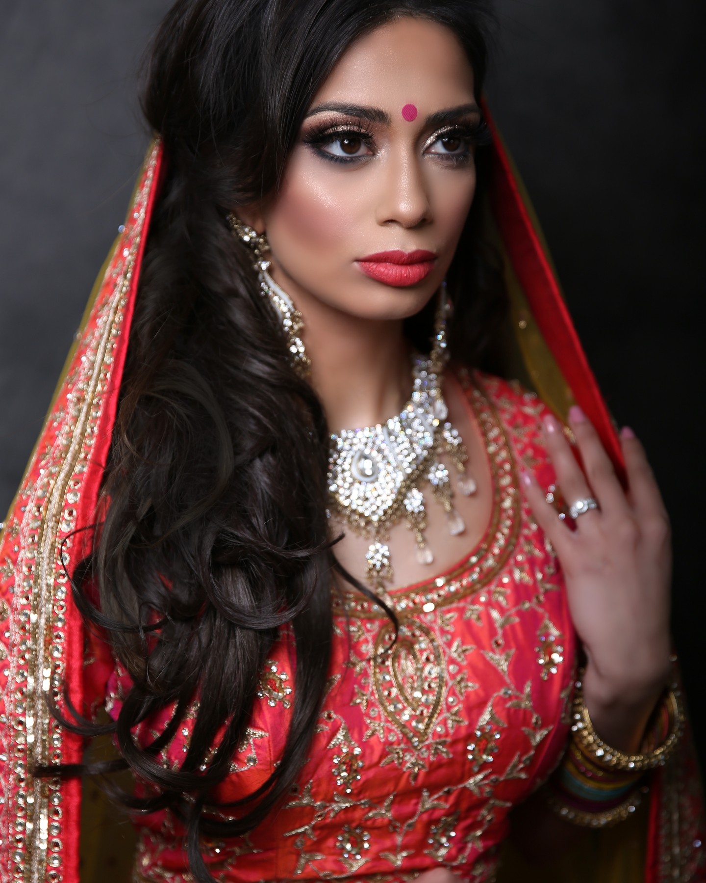Omar Saleem Photography - Bridal Portrait Photography in Birmingham - Close-up of a bride in a red and gold embroidered veil, featuring heavy jewelry and gold bridal makeup.